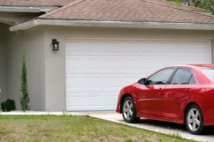 car-parked-front-wide-garage-double-door-concrete-driveway-new-modern-american-house